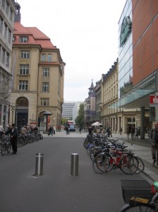 Many bikes, with modern and historic Leipzig buildings in the background