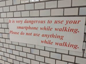 Sign: It is very dangerous to use your smartphone while walking. Please do not use anything while walking.